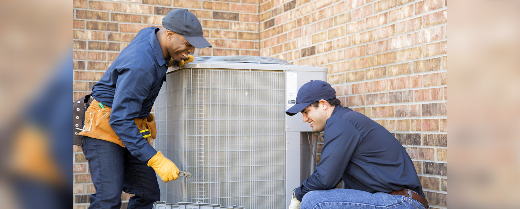 two men working outdoors on an air conditioner