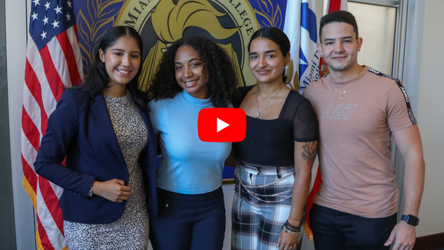 Four students standing in front of the MDC seal.